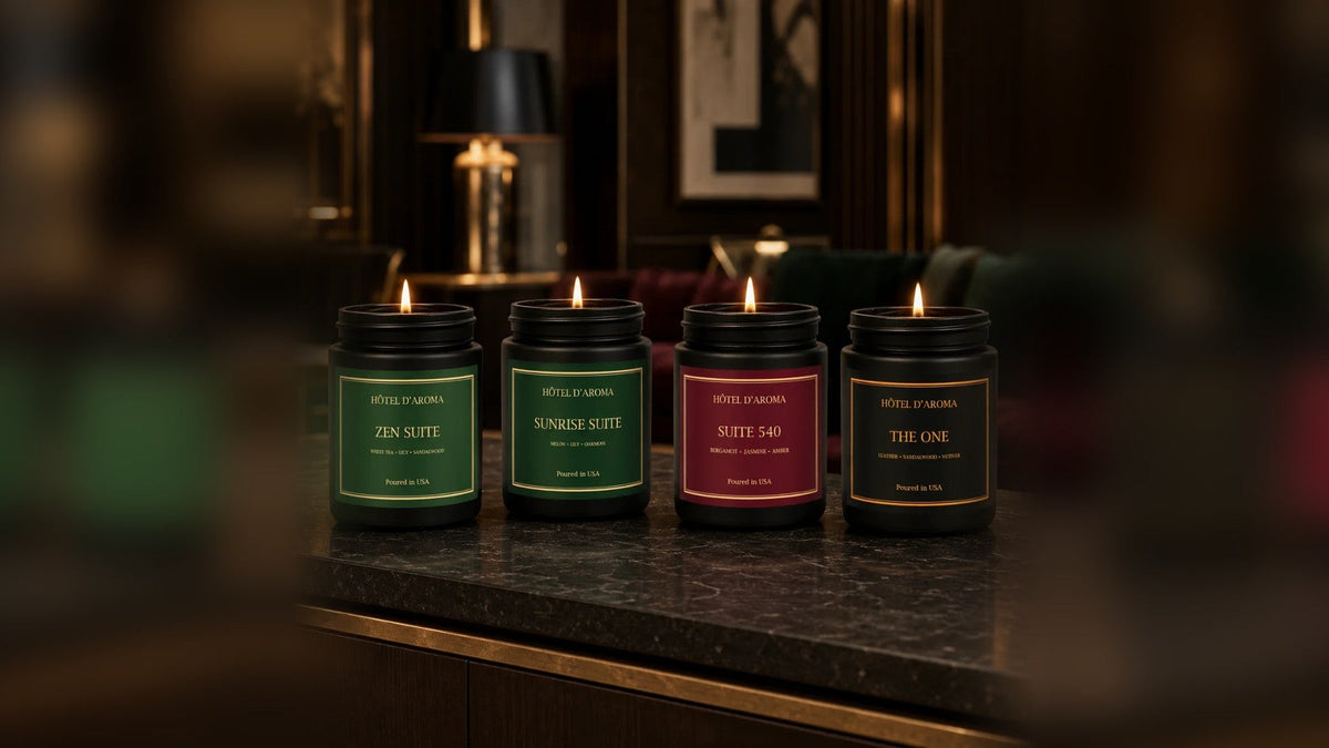 Four Hôtel d'Aroma candles from AROMA HOUSE MIAMI on a dark, moody bar