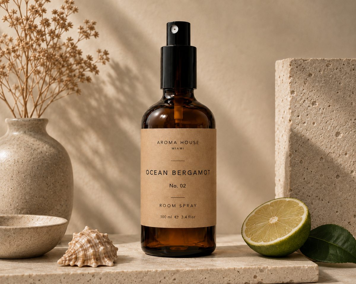 Ocean Bergamot room spray in amber glass bottle styled on a stone shelf, Aroma House Miami